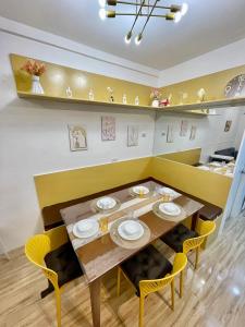 ein Esszimmer mit einem Holztisch und gelben Stühlen in der Unterkunft Primari Haven in Bantinguil