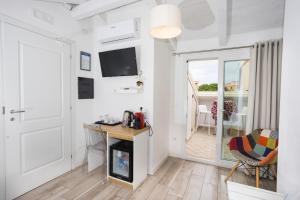 a living room with a desk and a television and a door at B&B Island Tropea -Sea View Rooms & Suites- in Tropea