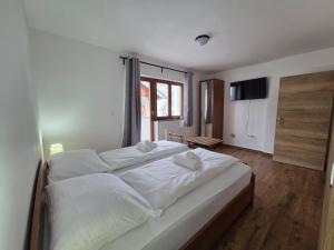 a bedroom with a large white bed with towels on it at Villa Roko - Gacka Valley in Ličko Lešće