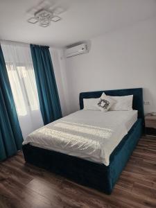 a bedroom with a bed with a blue headboard at Luxury LCF in Brăila