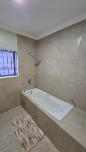 een grote badkamer met een bad en een vloerkleed bij Mafini Villa in Centurion