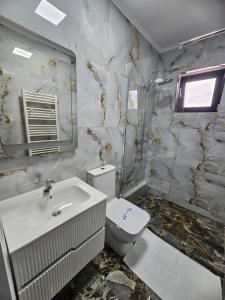 a white bathroom with a toilet and a sink at Luxury LCF in Brăila +25 photos