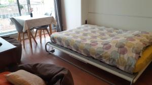 a bed in a room with a table and a chair at LePré Apartment 93 in Le Pré-Saint-Gervais