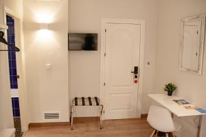 een kamer met een witte deur en een tafel en stoelen bij Hotel Universal Murcia in Murcia