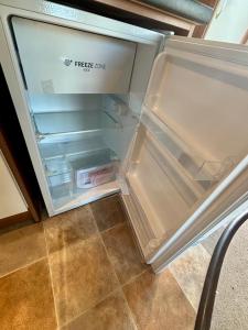 an empty refrigerator with its door open in a kitchen at Relax By The Coast - Spacious 6-sleeper Caravan in Leysdown-on-Sea