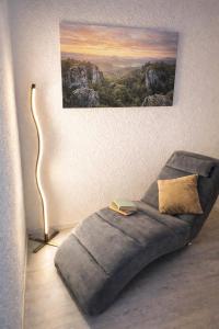 a couch in a living room with a painting on the wall at Waldblickwohnung mit schöner Terrasse und Kamin&Sauna in Sebnitz