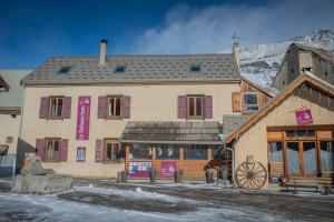 a large building in front of a snow covered mountain at Gite Le Rebanchon in Le Monêtier-les-Bains