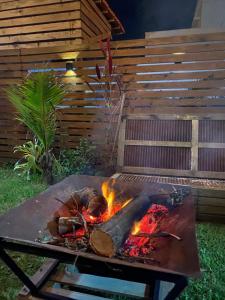 a grill with a fire in a yard at The Box Container House casa oceano in Imbituba