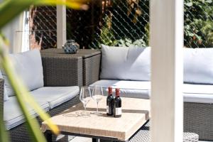 two bottles of wine and two glasses on a table at Pension am Pollingpark Haus II in Dessau
