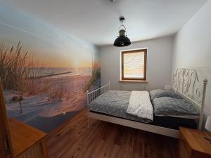 a bedroom with a bed and a painting of a beach at Plażowa Przytulny Dom Na Wyłączność in Białystok