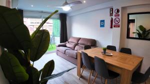 een woonkamer met een tafel en een bank bij Apartalux Ático Jaime I in Benidorm