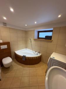 a bathroom with a tub and a toilet and a sink at Plażowa Przytulny Dom Na Wyłączność in Białystok +10 photos