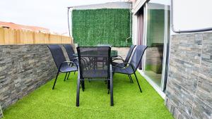 een tafel en stoelen op een patio met gras bij Apartalux Ático Jaime I in Benidorm
