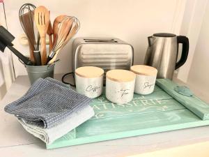 a tray with three cups and a toaster on a counter at Ocean Reef Retreat in Perth