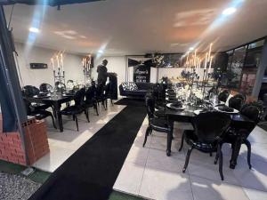 een man in een eetkamer met tafels en stoelen bij Mafini Villa in Centurion