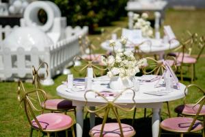 een groep tafels met roze stoelen en bloemen bij Mafini Villa in Centurion +77 foto's