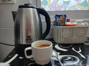 a cup of coffee on a counter next to a kettle at Merlo mar 2 in Merlo +4 photos