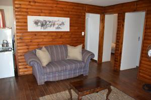 a living room with a couch and a table at Trout Ways in Waterval Boven