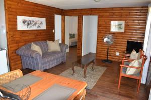 a living room with a couch and a table at Trout Ways in Waterval Boven