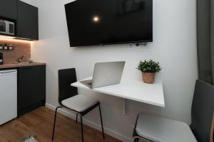 a kitchen with a white desk with a laptop on it at Stylish smart studio in Tallinn