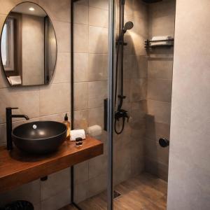 een badkamer met een wastafel en een douche bij Villa Park Luxury Rooms in Paralion astros