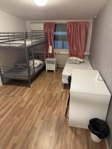 a room with two bunk beds and a desk at Frövi vandrarhem in Frövi