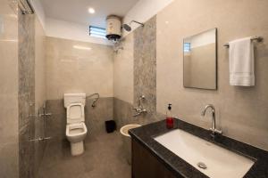 ein Badezimmer mit Waschbecken, Toilette und Spiegel in der Unterkunft Roomssolution ! Best Hotel In Patna in Gulzārbāgh + 17 Fotos
