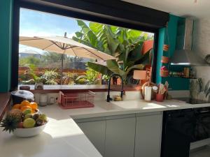 a kitchen with a bowl of fruit and an umbrella at Villa Exotiqua Sunset in La Saline les Bains
