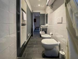 a bathroom with three toilets and two sinks at Affittacamere Bernardo Ricci in Albenga