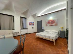 a bedroom with a bed and a table and a couch at Affittacamere Bernardo Ricci in Albenga