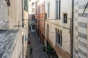 an alley between two buildings with a person walking down the street at Affittacamere Bernardo Ricci in Albenga