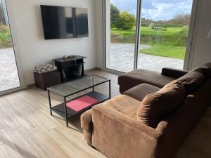 a living room with a couch and a glass coffee table at Chez Tristan in Plouguerneau