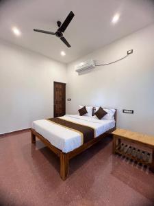 een slaapkamer met een bed en een plafondventilator bij VVR Residency in Kuilapayam