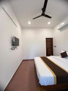 een slaapkamer met een bed en een flatscreen-tv bij VVR Residency in Kuilapayam