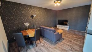 a living room with a blue couch and a table at Wohnen2a in Harsewinkel +5 photos