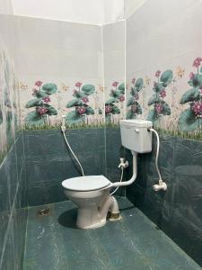 een badkamer met een toilet en een schilderij aan de muur bij VVR Residency in Kuilapayam