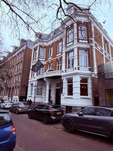 a building on a city street with cars parked in front at S&A Vondel Park Hotel in Amsterdam