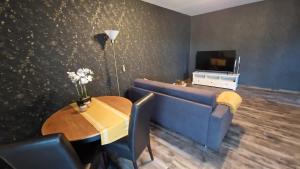 a living room with a blue couch and a table at Wohnen2a in Harsewinkel
