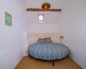 a bedroom with a bed in the corner of a room at La Garencière - La Petite Maison in Champfleur
