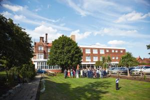 a group of people standing in the grass in front of a building at The Orwell Hotel in Felixstowe