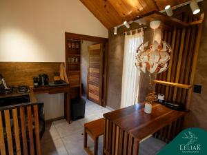 a kitchen with a wooden table and a chandelier at Hospedaria Leliak - Retiro Boutique de Montanha in Aiuruoca
