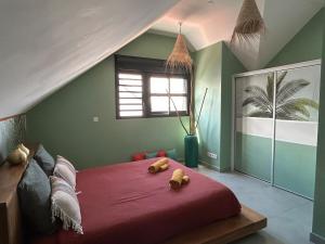 a bedroom with a red bed with two teddy bears on it at Villa Exotiqua Sunset in La Saline les Bains +57 photos