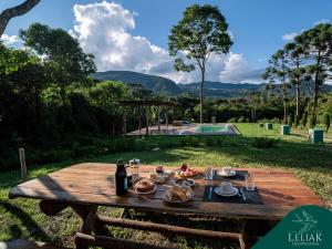 a picnic table with food on top of it at Hospedaria Leliak - Retiro Boutique de Montanha in Aiuruoca