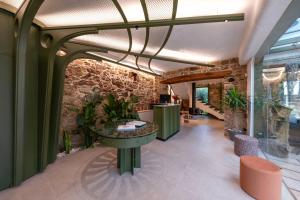 a lobby with a table and a stone wall at Hotel Sarela Natura in Santiago de Compostela