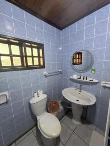 a blue tiled bathroom with a toilet and a sink at Diamond Plaza in Grand Anse +60 photos