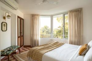 a bedroom with a bed and a large window at El Volar by The Blue Kite - 2BHK, 5 Mins to Casino & 10 Mins to Candolim Beach with Big common Pool, Fully Equipped Kitchen, 24x7 Security, WiFi in Nerul