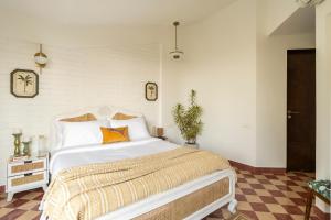 a bedroom with a large white bed with an orange pillow at El Volar by The Blue Kite - 2BHK, 5 Mins to Casino & 10 Mins to Candolim Beach with Big common Pool, Fully Equipped Kitchen, 24x7 Security, WiFi in Nerul
