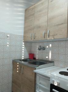a kitchen with a sink and wooden cabinets at Apartman Marinamar in Utjeha +21 photos