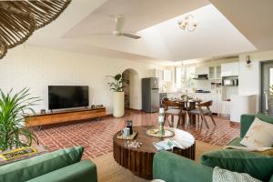 a living room with a couch and a tv and a table at El Volar by The Blue Kite - 2BHK, 5 Mins to Casino & 10 Mins to Candolim Beach with Big common Pool, Fully Equipped Kitchen, 24x7 Security, WiFi in Nerul +272 photos