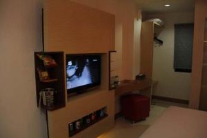 una habitación con TV en la pared en Antoni Hotel, en Yakarta